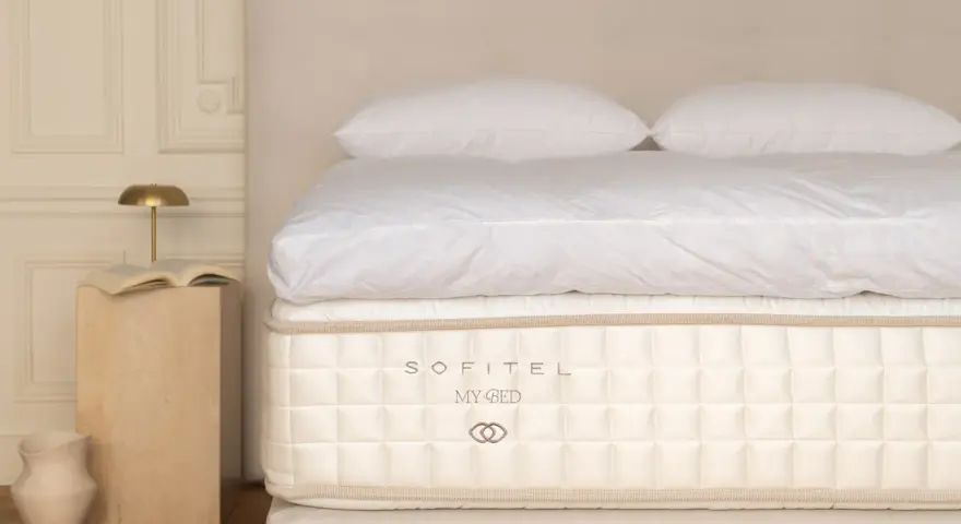 Un matelas Sofitel My Bed, symbole d'un choix literie de luxe, avec des draps blancs et des oreillers moelleux.