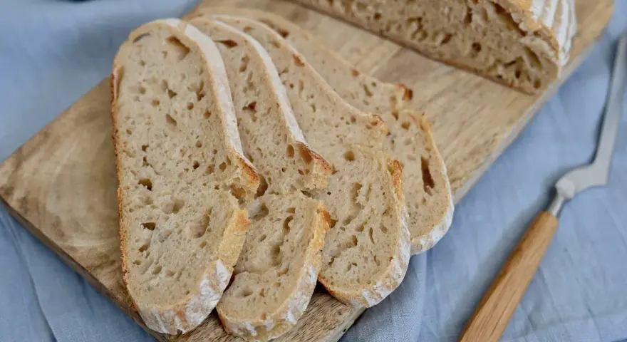 Aufgeschnittenes italienisches Brot mit Lievito Madre auf einem Holzbrett, bereit zum Genießen.