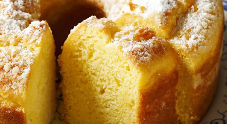 Un soffice ciambellone allo yogurt, cosparso di zucchero a velo, pronto per essere gustato.
