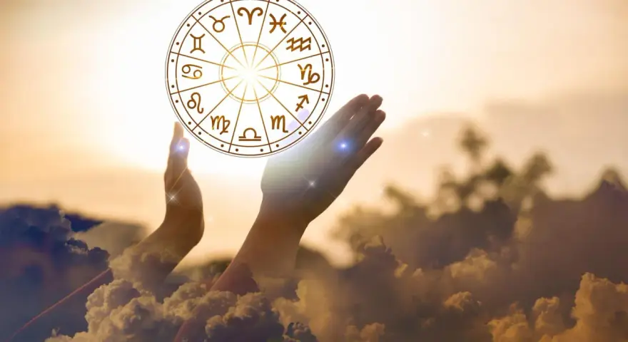 Dłonie unoszą koło zodiaku, symbolizując drogę do tego, jak obliczyć numer astrologiczny.