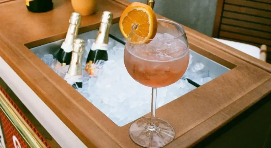Orzeźwiający Aperol z pomarańczą i butelkami prosecco w lodzie. Idealne na letnie popołudnie.