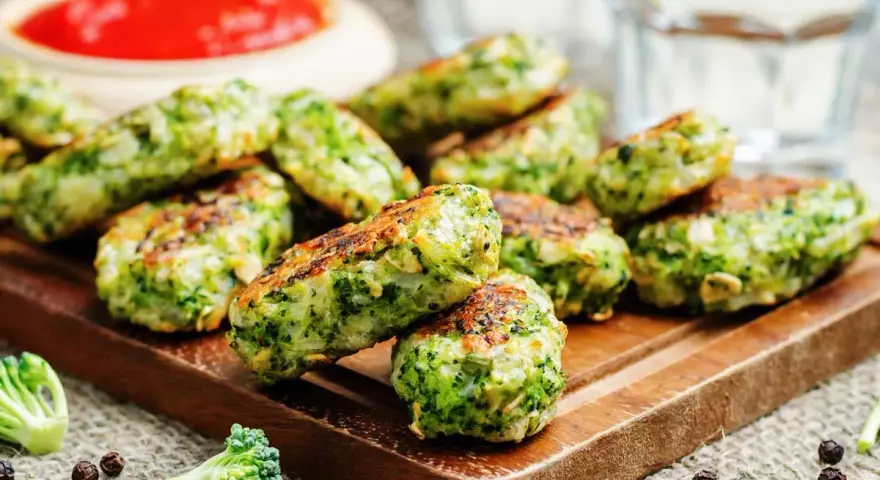 Deliciosas bolitas de brócoli, perfectas para tus recetas con brócoli. Servidas con salsa roja y un toque de pimienta.