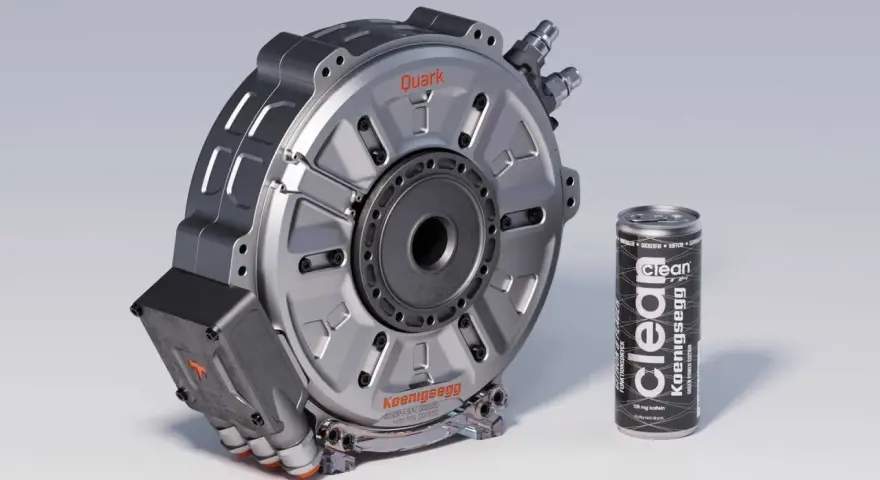 Silnik elektryczny Koenigsegg Quark obok puszki napoju energetycznego.