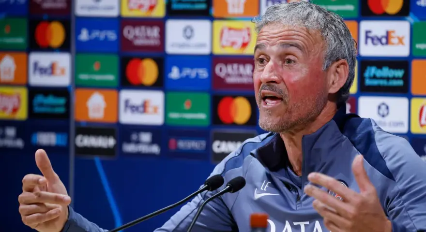 Luis Enrique, trener PSG, z pasją opowiada o tym, kto wygra Ligę Mistrzów, gestykulując przed mikrofonami.