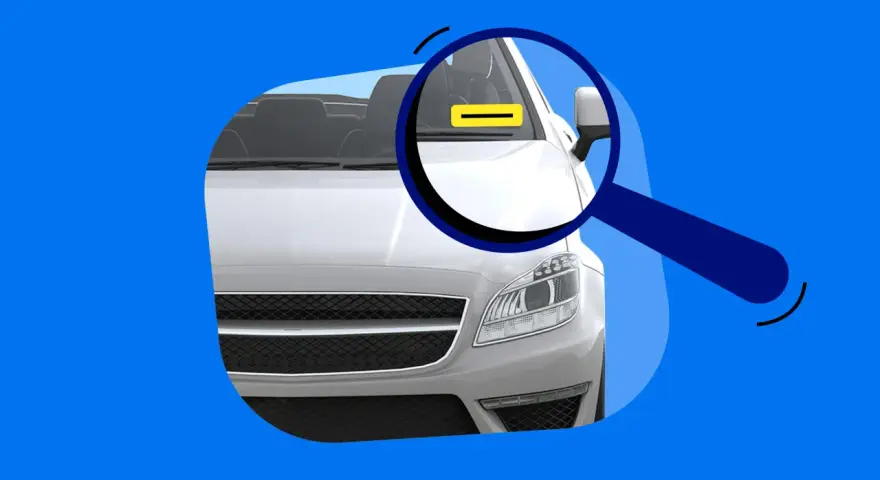 Lupe über dem Auto, die auf eine gelbe Markierung am Armaturenbrett zeigt. Das erklärt, was bedeutet FIN beim Auto.