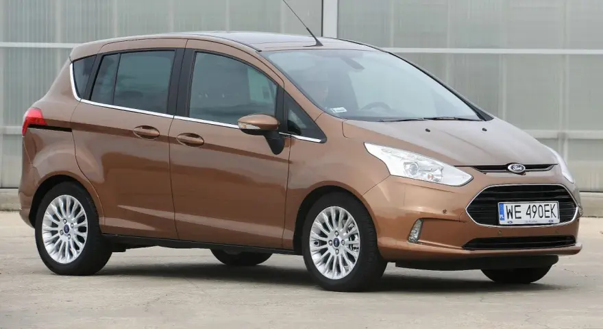 Brązowy Ford B-Max z polskimi tablicami WE 490EK zaparkowany na zewnątrz.