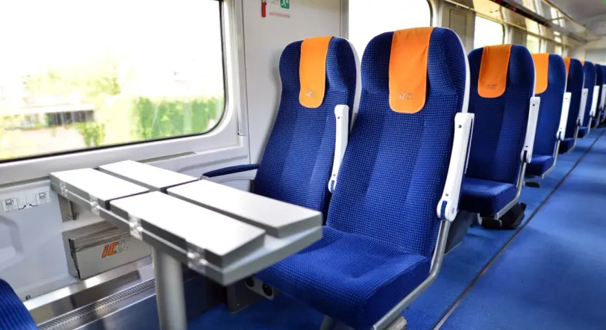 Wygodne siedzenia w pociągu PKP Intercity, gotowe na podróż do Warszawy.