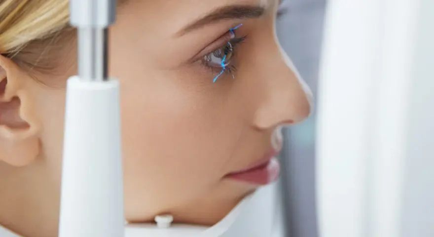 Esame oculistico: una donna con linee blu che indicano la pseudofachia dell'occhio.