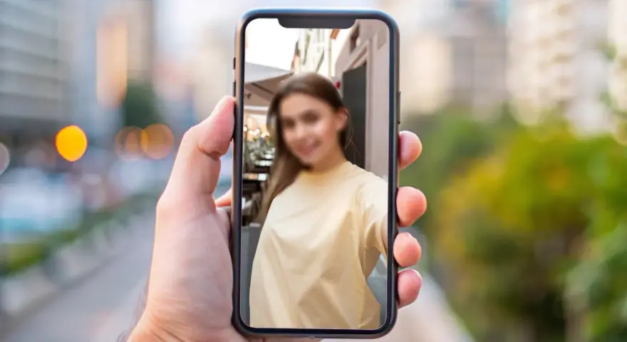 Chcesz wiedzieć, jak zamazać twarz na zdjęciu iPhone? Na ekranie telefonu widać rozmazaną twarz młodej kobiety.