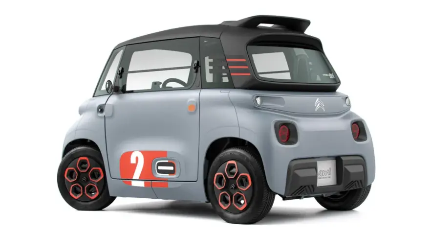 Szary Citroen Ami z pomarańczowymi akcentami i numerem 2. Ten elektryczny pojazd oferuje zaskakujący zasięg na jednym ładowaniu.