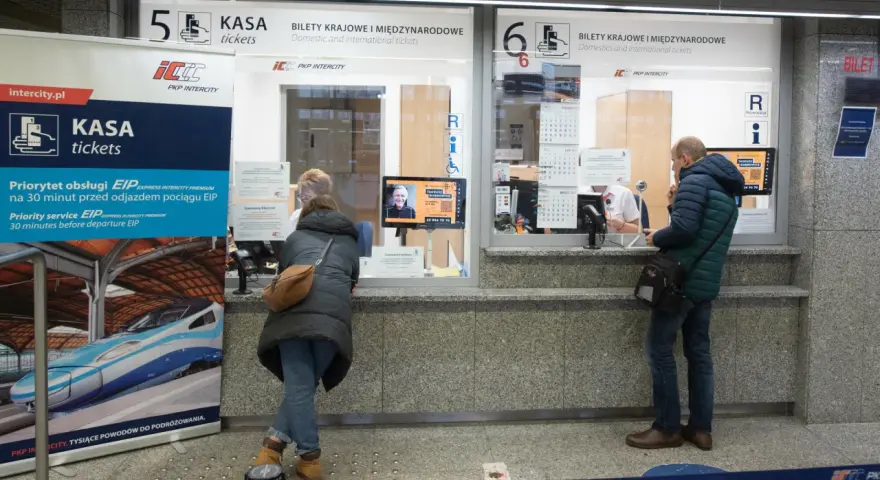 Kasa PKP Intercity w Poznaniu, gdzie kupisz bilety na pociąg do Warszawy. Ludzie stoją w kolejce do okienka.