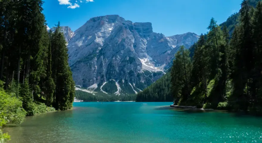 Lago di Braies, perla del tour Trentino, con montagne imponenti e acque cristalline.