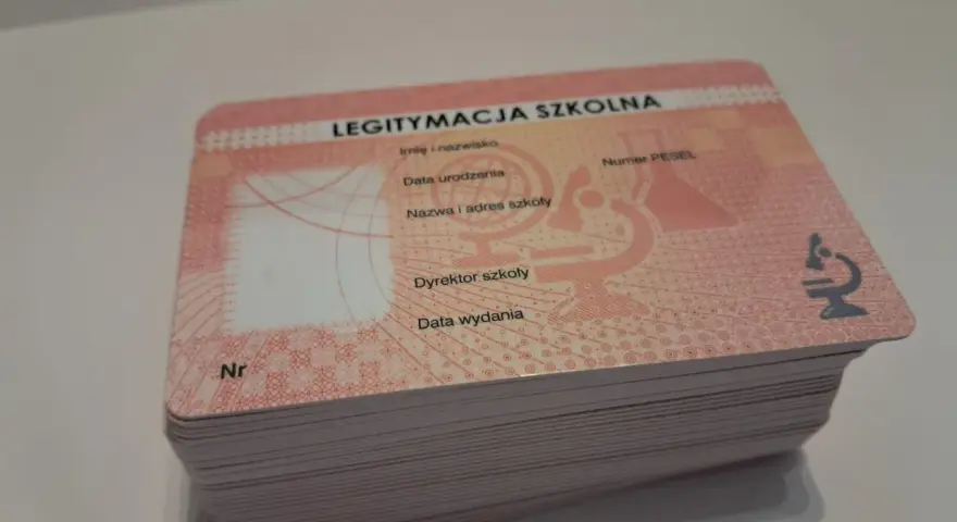 Stos nowych legitymacji szkolnych z miejscem na zdjęcie i danymi ucznia.