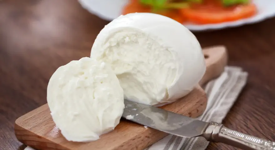 Świeża mozzarella na desce, gotowa do sałatki. Czy mozzarella jest wegetariańska? Tak, tradycyjnie tak!
