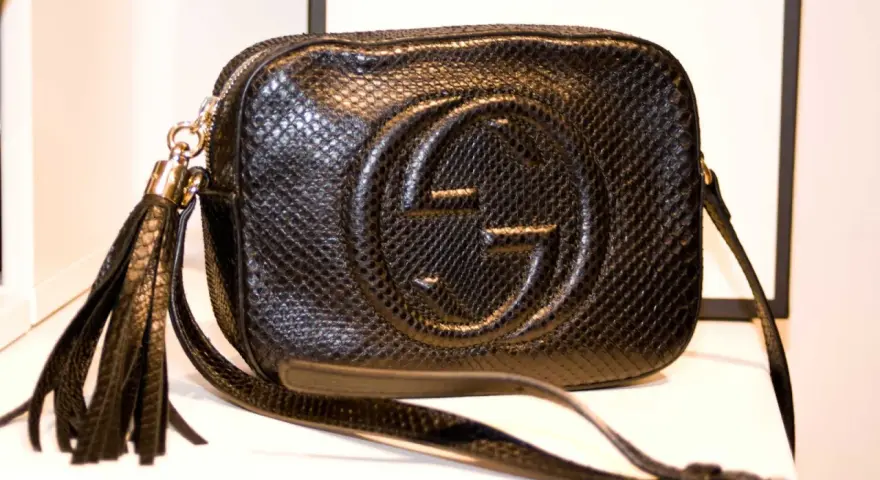 Czarna, pikowana torebka Gucci z wytłoczonym logo i frędzlami. Klasyczne, stylowe modele torebek Gucci.