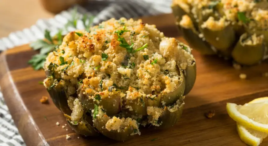 Carciofi ripieni e dorati, cotti alla perfezione nella friggitrice ad aria, guarniti con prezzemolo fresco e spicchi di limone.