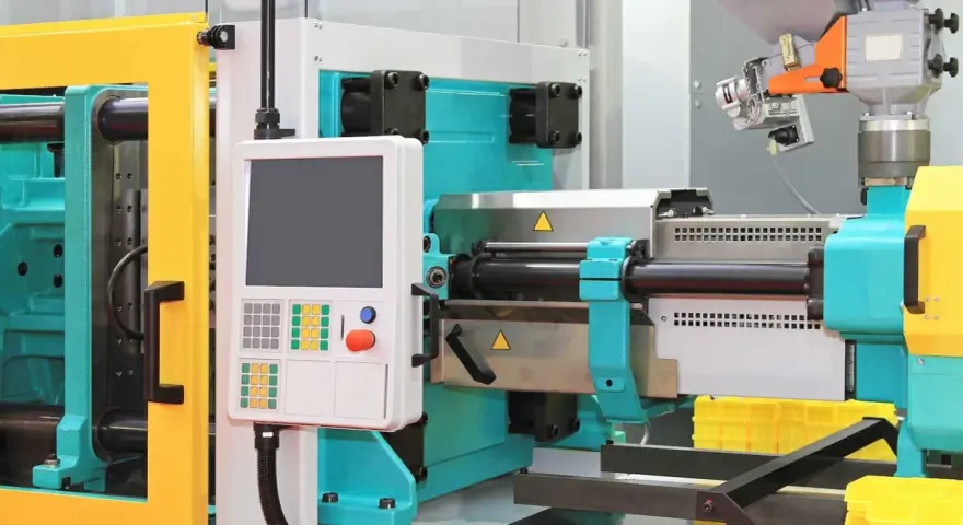 A modern low volume plastic injection molding machine with a control panel and yellow safety guards.