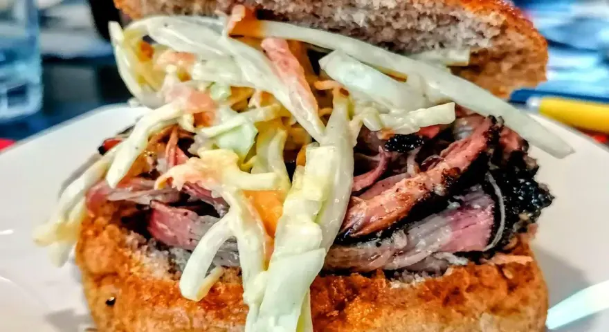 Sandwich con pulled pork, un classico della pulled pork ricetta, con pane integrale e insalata coleslaw cremosa.