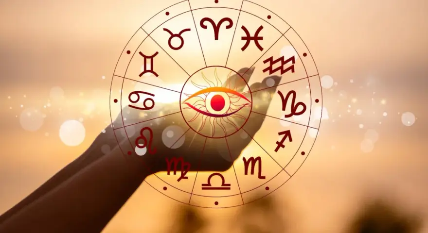 Oko opatrzności w centrum koła zodiaku, z symbolem Koziorożca widocznym na tle zachodzącego słońca. Twój horoskop dzienny czeka!