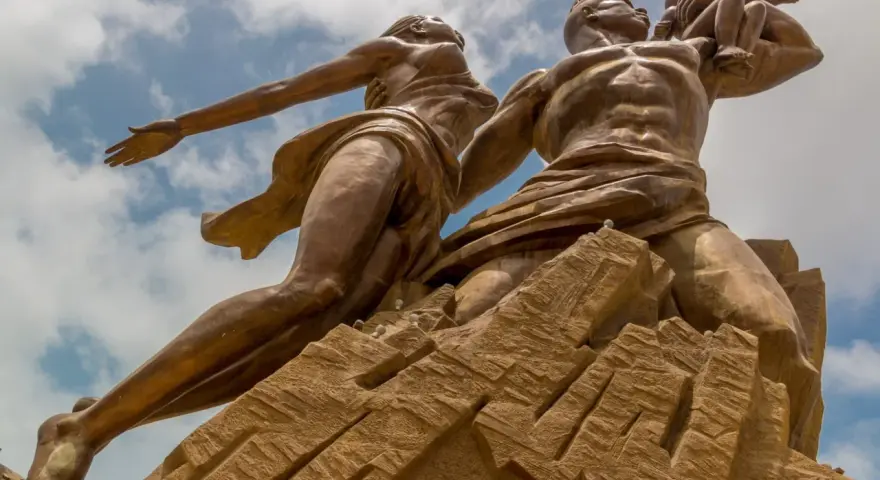 Pomnik Odrodzenia w Senegalu, symbolizujący dumę i przyszłość. Monumentalna rzeźba na tle błękitnego nieba.
