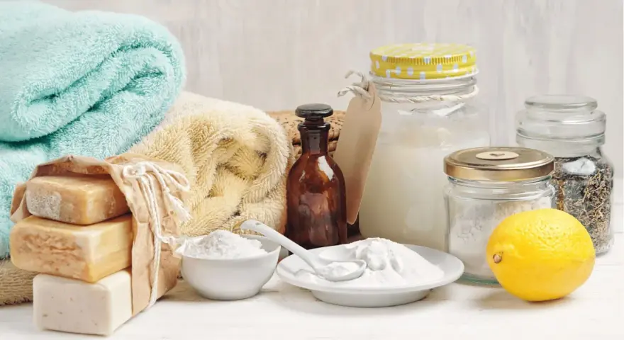 Ingrédients pour une recette lessive maison qui sent bon : savons, bicarbonate de soude, citron, herbes séchées.