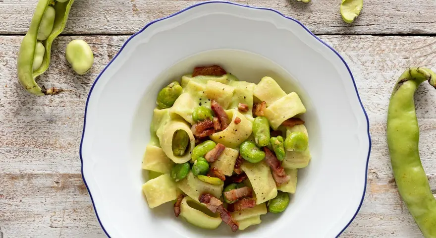 Piatto di pasta con fave fresche e croccante pancetta, un classico saporito.