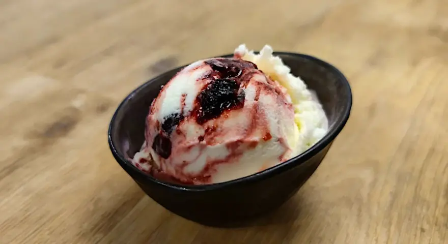 Ein Löffel cremiges Amarena Eis mit Kirschsauce und einem Hauch von Alkohol.