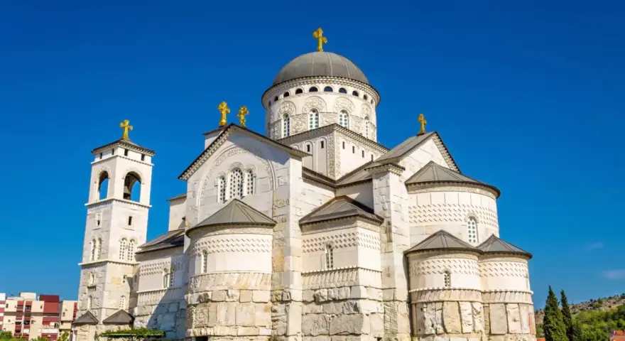 Sobór Zmartwychwstania Chrystusa, imponująca budowla w stolicy Czarnogóry, Podgoricy, z dominującą kopułą i złotymi krzyżami.