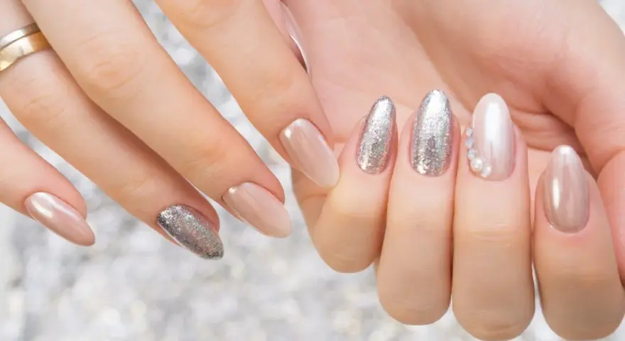 Mani curate con unghie eleganti, un mix di nude perlato e glitter argento, perfetti colori smalto primavera.