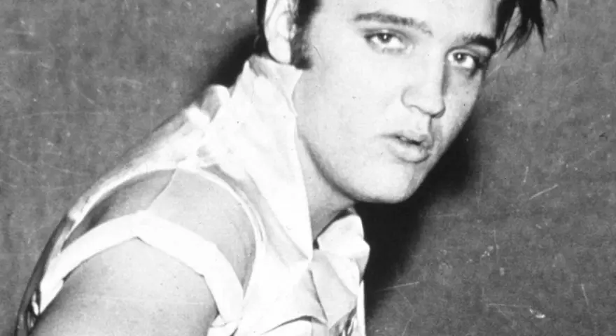 Junger Elvis Presley, mit seinem charakteristischen Blick und jugendlichem Charme, blickt in die Kamera.