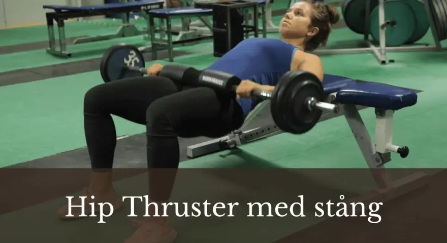 Kvinna utför hip thrust med stång på en bänk i ett gym.