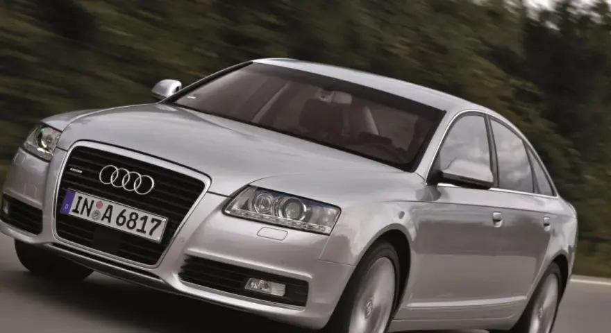 Silberner Audi A6 Limousine 2005 fährt auf einer Landstraße.