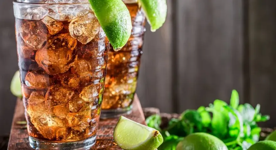 Dwa orzeźwiające drinki z rumem i lodem, ozdobione limonką. Idealne na upalne dni, zastanawiasz się, jaki rum do herbaty będzie najlepszy?