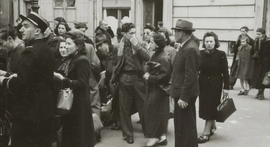 Une foule se presse devant "Union Vinicole" et "Coiffeur". L'atmosphère est tendue, évoquant la rafle du billet vert.