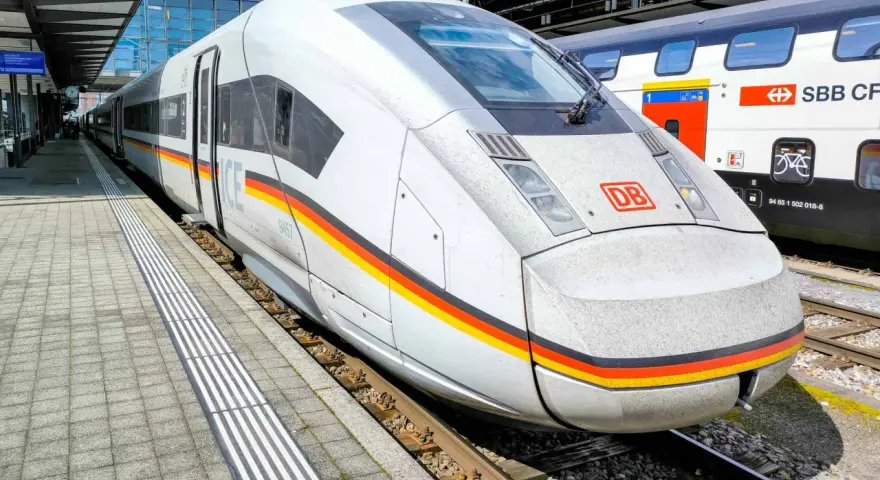 ICE train with German flag colors at a station, ready for a journey between Germany and Switzerland.