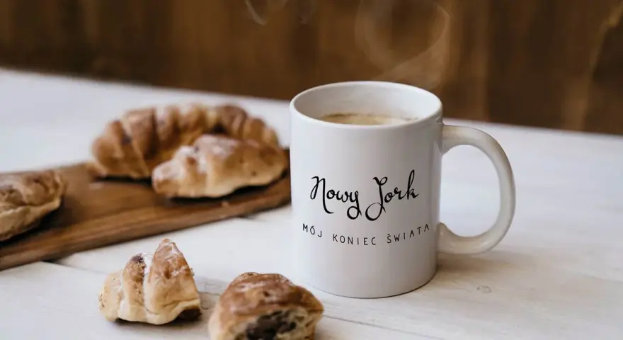 Kawa i croissanty, idealne na śniadanie. Kubek z napisem "Nowy Jork, mój koniec świata" to świetny pomysł, co kupić w USA do Polski.