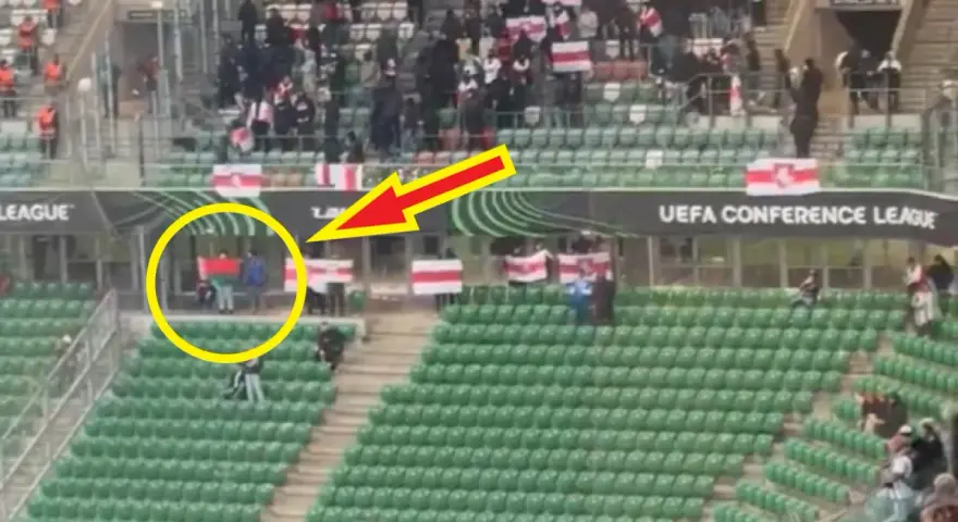 Widzimy jak wygląda flaga Legii: zielono-czerwono-zielona. Kibice na trybunach, część z nich trzyma biało-czerwone flagi.
