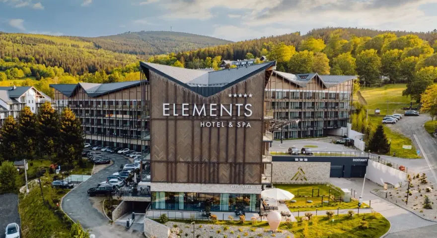 Nowoczesny hotel przy stoku narciarskim w Polsce, Elements Hotel & Spa, otoczony zielenią i górami. Idealne miejsce na zimowy wypoczynek.