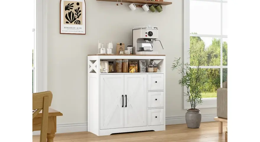 Muebles pintados en blanco y madera, con cafetera y plantas, en una cocina luminosa.