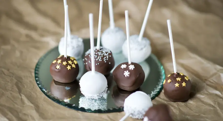 Läckra cakepops med choklad och vit glasyr, dekorerade med stjärnor och snöflingor. Ett enkelt cakepops recept att prova!