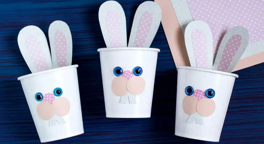 Drei süße Osterhasen-Becher, perfekt für Ostern basteln mit Kleinkindern. Bunte Ohren und lustige Gesichter machen sie zum Hingucker.