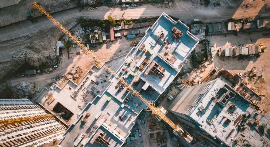 Aerial view of a construction site, showcasing the efficiency of drones in construction by providing an overhead perspective of building progress and material placement.