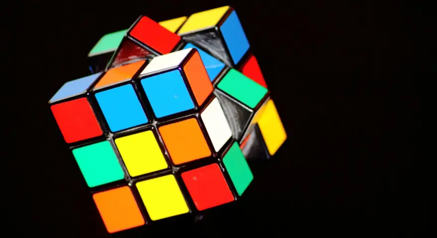 En färgglad rubiks kub 3x3 ligger på en mörk bakgrund.