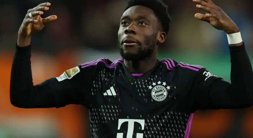 Alphonso Davies, jugador del Bayern de Múnich, celebra con las manos en alto.