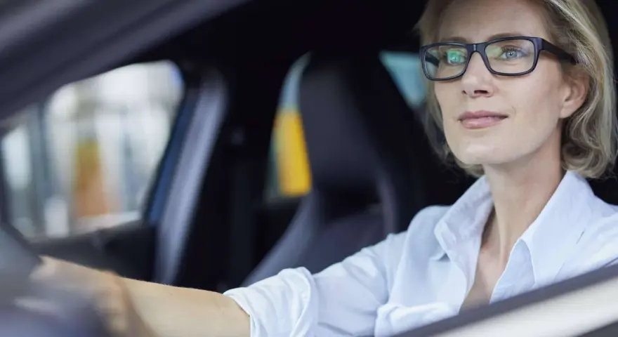Frau mit Brille fährt Auto. Ohne Brille fahren ohne Brille Strafe.