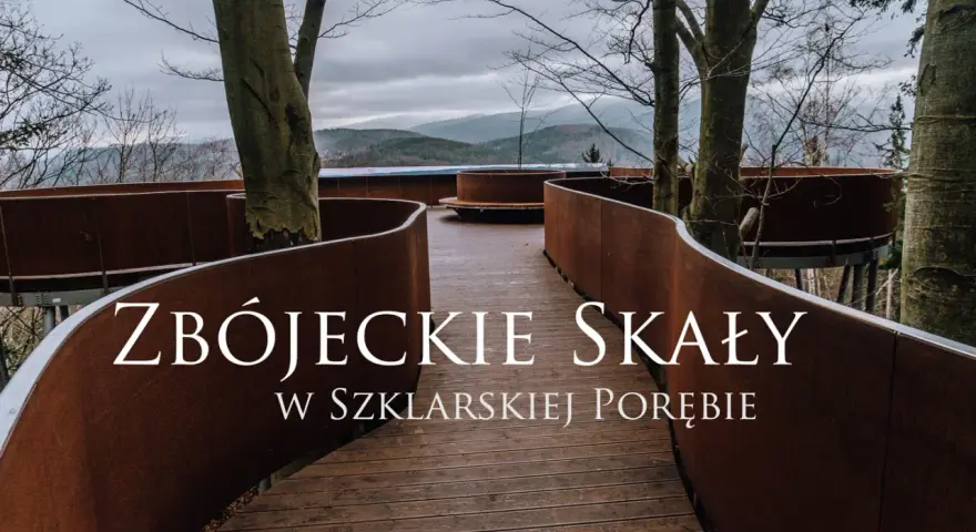 Złoty widok ze ścieżki w koronach drzew w Szklarskiej Porębie. Drewniana kładka z rdzawo-brązowymi balustradami wije się wśród drzew, prowadząc do punktu widokowego.