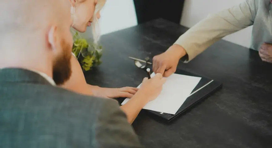 Para z dumą podpisuje dokumenty, finalizując swoją ugoda.