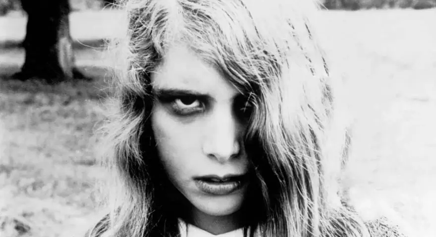 Primo piano di una bambina con sguardo inquietante, capelli lunghi e spettinati. Un'immagine iconica per chi ama i film trash da vedere.