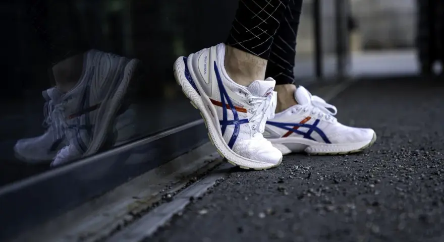 Vita Asics-skor med blå och röda detaljer, perfekt för löpning. Kolla in vår asics storleksguide för rätt passform.