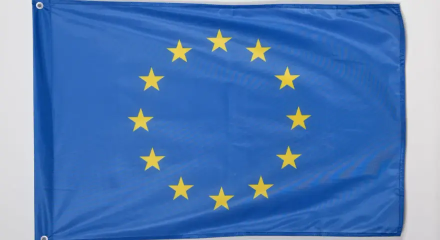 Flaga Unii Europejskiej, symbol jedności i współpracy, z dwunastoma złotymi gwiazdami na niebieskim tle.